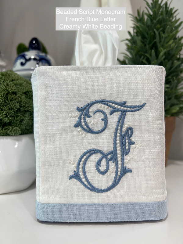 White Linen Tissue Cover with baby blue edge and beaded monogram letter F in French Bleu letter and creamy white beading.