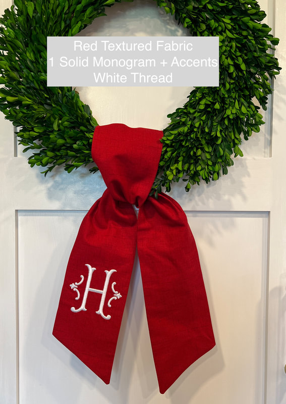 Bright Red Textured Fabric Wreath sash with Single Solid monogram in white thread with accents on either side.